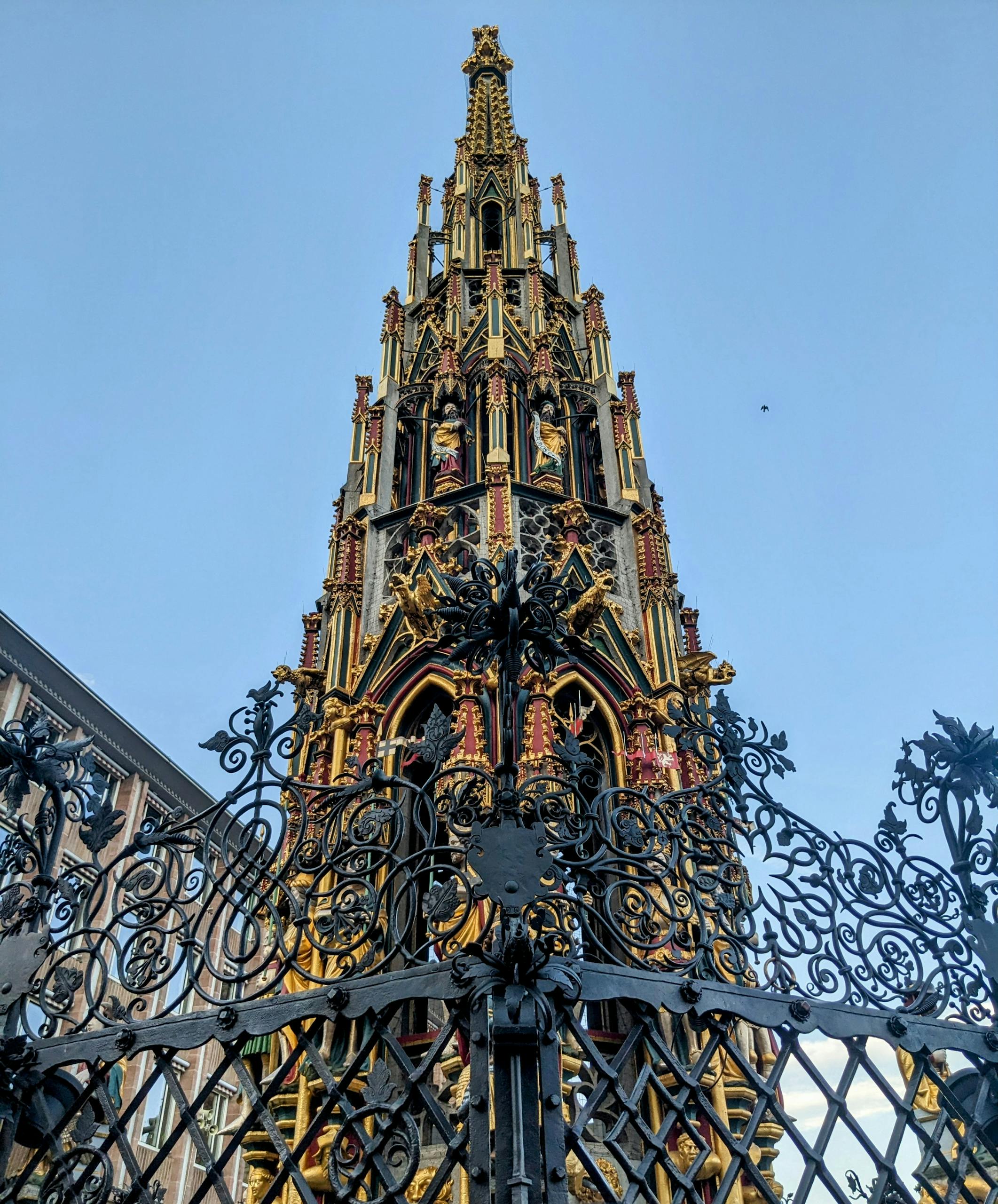 A tall tower with ornate metalwork and a gate