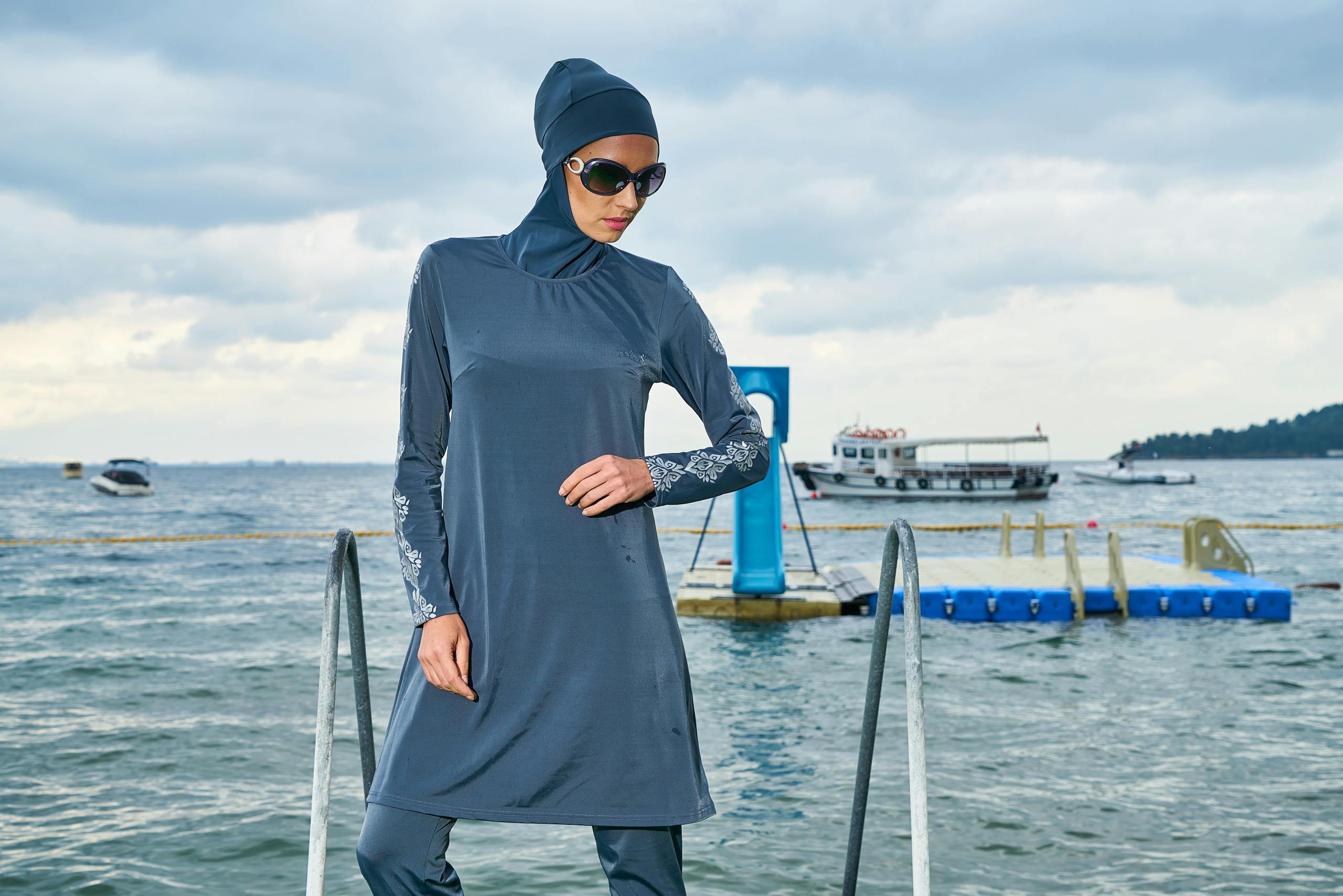Woman in Blue Hijab and Long-sleeved Dress Standing Near Body of Water